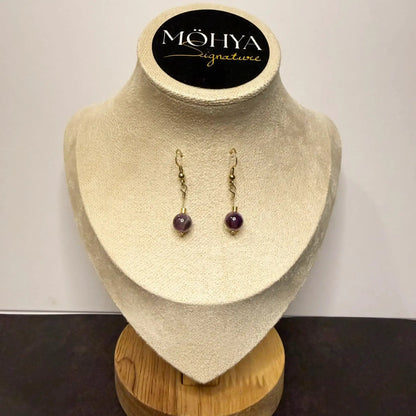 Brincos de prata com pedra ametista, design pendente, expostos em busto de veludo bege.