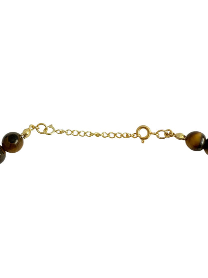 Fecho de colar ajustável dourado com contas de pedra natural sobre fundo branco.