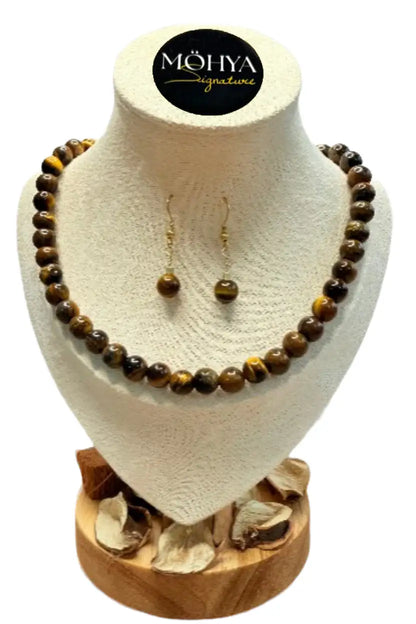 Conjunto de colar e brincos de contas marrons em expositor, joias artesanais elegantes.