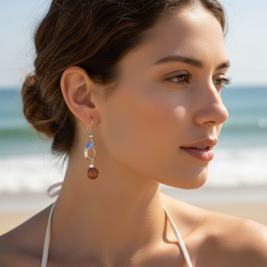 Mulher na praia usando brincos em prata com pedras naturais